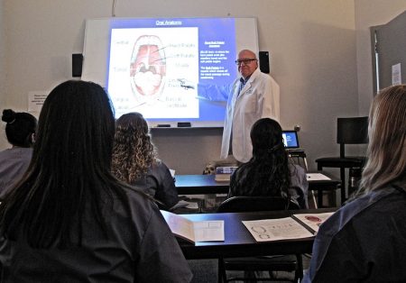 Dr. Erickson showing students a diagram of the oral anatomy.