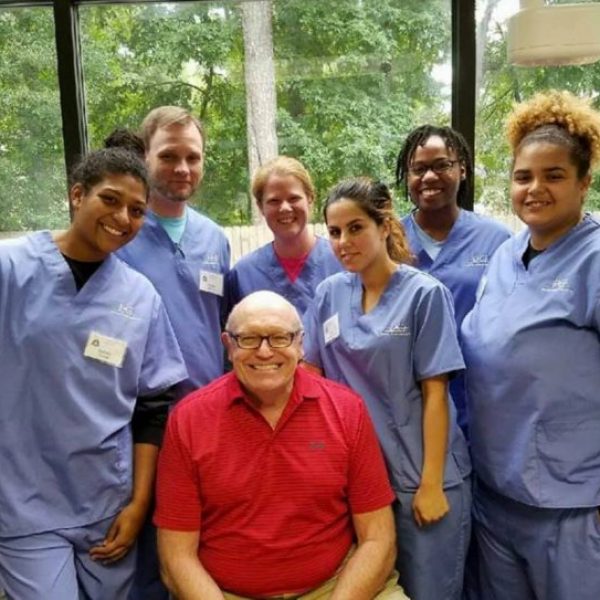 Dr. Erickson smiling with a group of dental students.