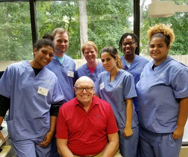 Dr. Erickson smiling with a group of dental students.