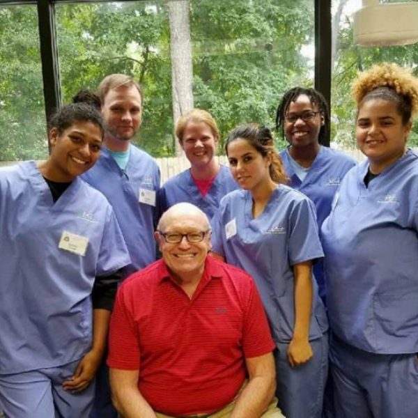 Dr. Erickson smiling with a group of dental students Dr. Erickson smiling with a group of dental students.