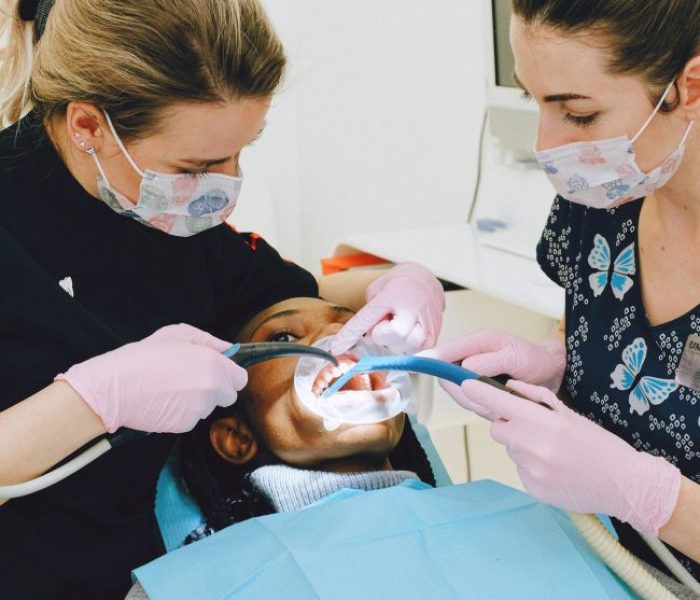 female-dentist-with-assistant-treating-patient-in-clinic-3845951 Female dentist with assistant treating patient in clinic.